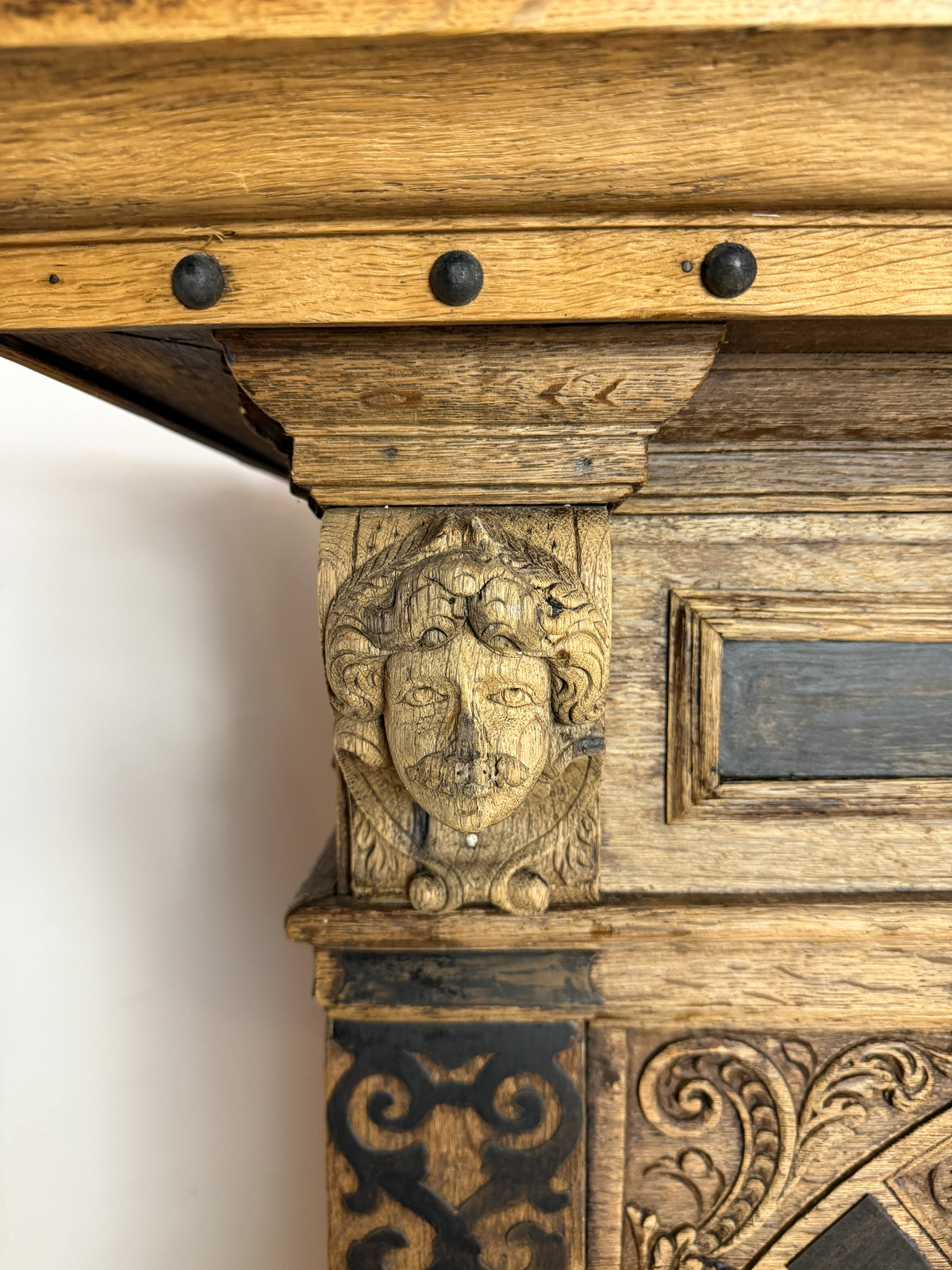 Wooden architectural detail with carved face and decorative patterns
