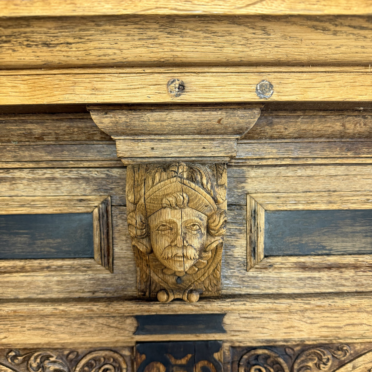 Decorative wooden panel with carved face and intricate patterns